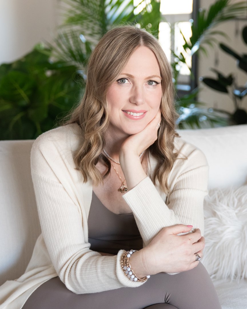 Tabitha Green smiling on a white sofa